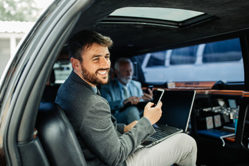 Wall Mural - Two businessmen in limousine working together.