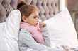 Little girl suffering from cough and cold in bed at home