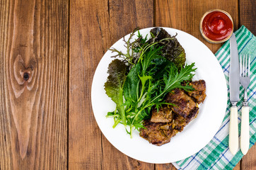 Wall Mural - Slices of fried liver, green leaves of salads