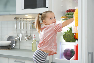 Sticker - Cute girl choosing food from refrigerator in kitchen