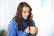 © New Africa - Young beautiful woman in warm sweater with cup of hot drink at home