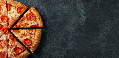 Fotomural Tasty pepperoni pizza and cooking ingredients tomatoes basil on black concrete background