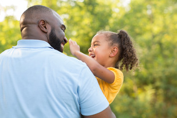 Wall Mural - Father laughing and playing with his daugher.