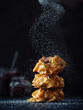 © fascinadora - Ideas and recipes for sweet baking. Fillonuts - peanut butter and jelly fillo doughnuts sprinkled powdered sugar. On black background. Copy space for text. Vertical.
