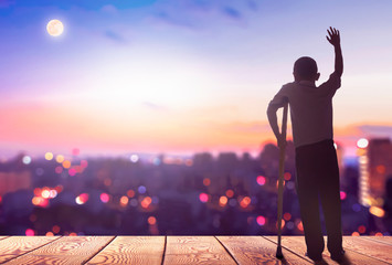 Wall Mural - International Day of Persons with Disabilities concept? Silhouette a disabled man standing at mountain city background