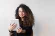 © ElisaCreative - Beautiful woman with curly hair dressed on black working or shopping using computer or tablet