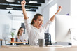 © Drobot Dean - Happy excited business woman in office working with computer make winner gesture.