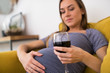 Concerned Pregnant Woman Drinking Red Wine At Home