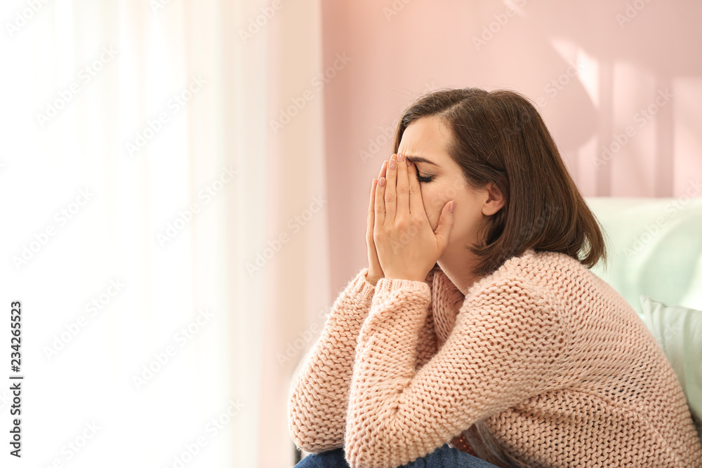 Lonely depressed woman on bed at home