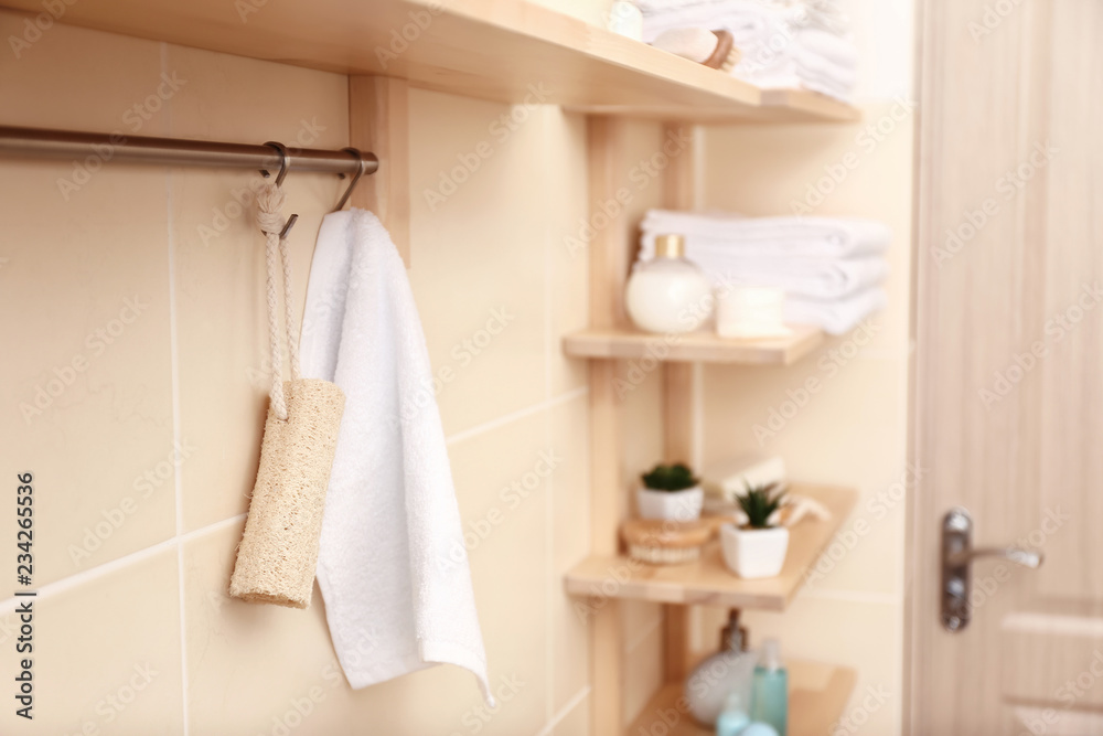 Rack with white terry towel and loofah in bathroom