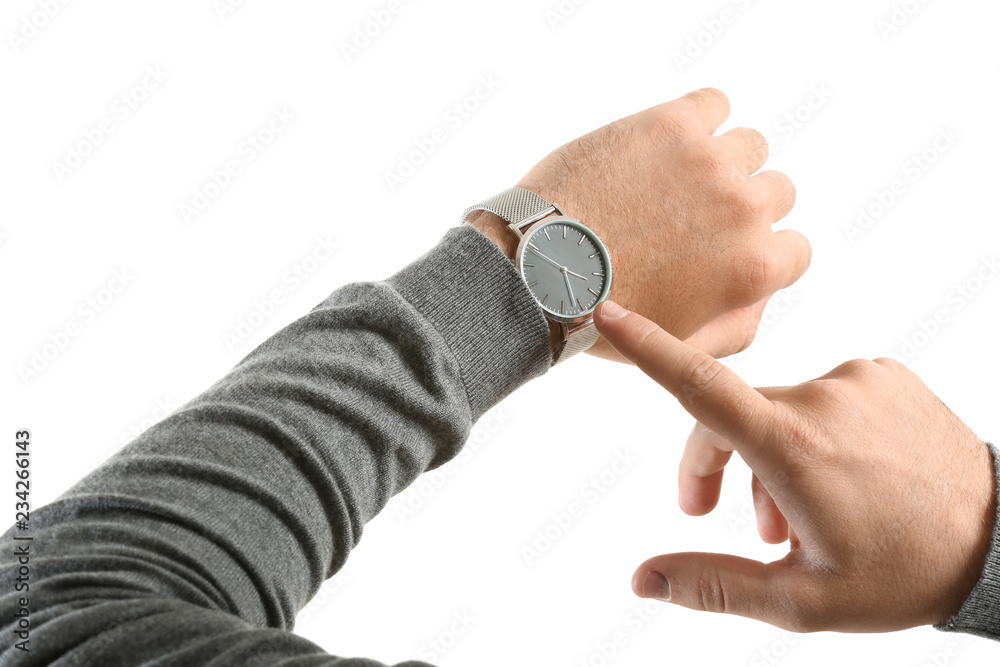 Young man pointing at his watch on white background