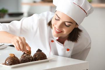 Young female chef cooking tasty dessert in kitchen