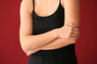 © Pixel-Shot - Young woman suffering from pain in elbow on color background
