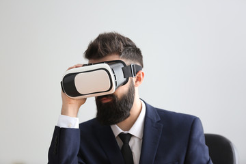 Wall Mural - Businessman wearing virtual reality glasses in office