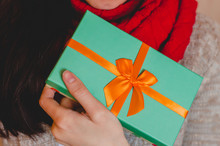 Young Woman Holds A Gift Box With A Bow Close Up