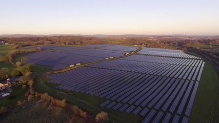 Wall Mural - Aerial drone view of solar panels at a solar energy generation farm at Sunset in South Wales, UK