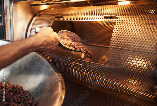 Cuadros en Lienzo Worker in a chocolate making factory roasting cocoa beans