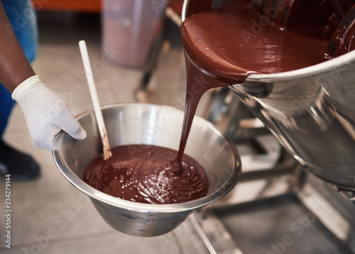 Fotomural Melted chocolate pouring into a bowl in confectionary factory