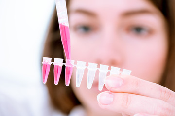 Canvas Print - Young woman fill PCR microtubes with dispenser