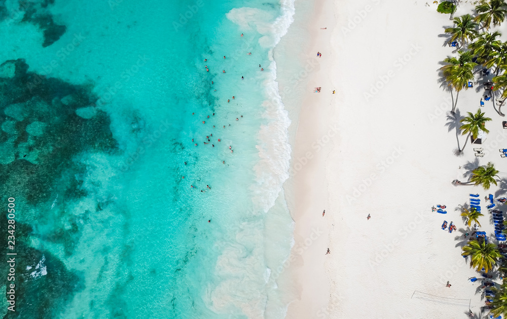 Incredible view of the white sandy beach from a bird's eye view. Top view of beautiful white sand beach with turquoise sea water and palm trees, aerial drone shot.  - obrazy, fototapety, plakaty 