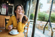 © bnenin - Happy woman drinking coffee at the cafe.
