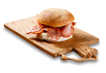 Bacon roll on a wooden board.