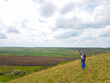 © vadiar - a young woman with red hair and a blue denim dress is in the mountains outside the city and is trying to catch a cellular connection.