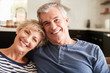 © Monkey Business - Senior couple relaxing at home smiling to camera, close up