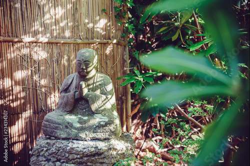 Stone Statue Of Buddhist Monk Sitting In Meditation In Japanese
