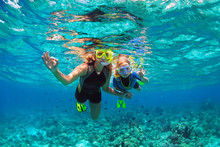 Happy Family - Mother, Kid In Snorkeling Mask Dive Underwater With Tropical Fishes In Coral Reef Sea Pool. Show By Hands Divers Sign OK. Travel Lifestyle, Beach Adventure On Summer Holiday With Child.
