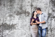 © Marharyta Hanhalo - Couple in love is kissing and hugging over the grey urban wall in the morning city. Man and woman are having great time together. Ancient old european city street with stone walls.