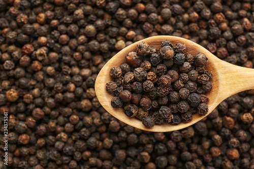 spoon-with-black-pepper-over-heap-of-grains-top-view