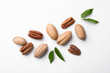 Composition with pecan nuts and leaves on white background, top view