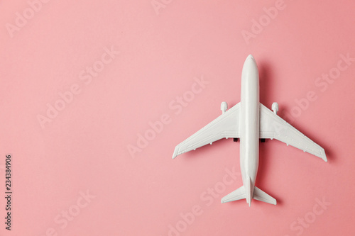 Fényképezés Simply flat lay design miniature toy model plane on pink pastel colorful paper trendy background