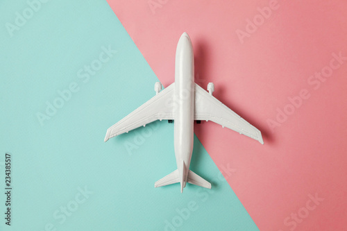 Fényképezés Simply flat lay design miniature toy model plane on blue and pink pastel colorful paper trendy geometric background