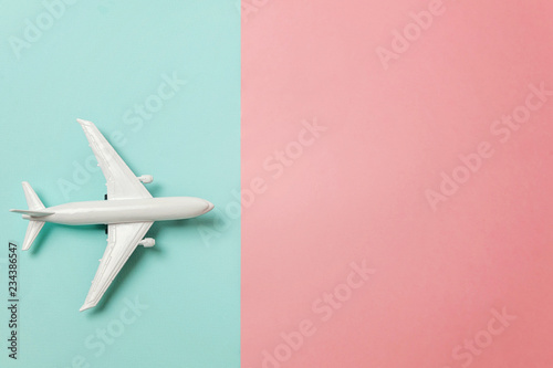 Fényképezés Simply flat lay design miniature toy model plane on blue and pink pastel colorful paper trendy geometric background