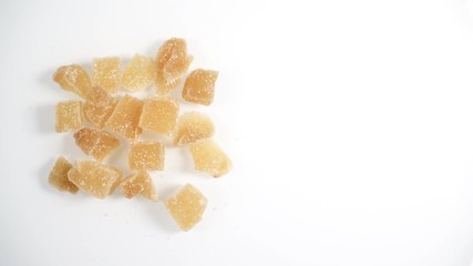 Wall Mural - Top down view. Heap of crystallized candied ginger pieces rotating on white.  Yummy snack, better alternative to candy