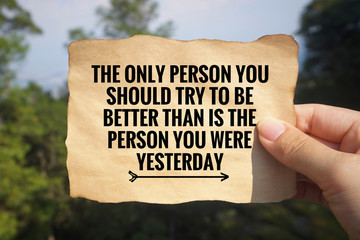 Inspirational and motivational quote - ‘The only person you should try to be better than is the person you were yesterday’ written on a white paper. Vintage styled blurry background.