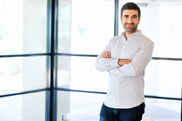 Wall Mural - Young caucasian businessman standing in office