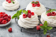mini pavlova  meringue cakes with whipped cream and fresh raspberry