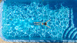 © Iuliia Sokolovska - Active girl in swimming pool aerial drone view from above, young woman swims in blue water, tropical vacation, holiday on resort concept