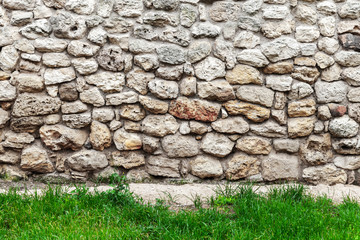 Old stone wall and fresh green grass