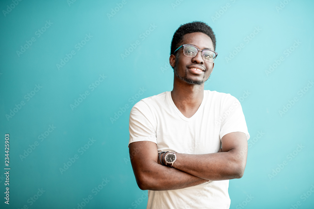 Portrait of a young african man dressed in white t-shirt standing on ...