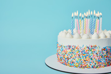 delicious birthday cake with lighting candles on blue background