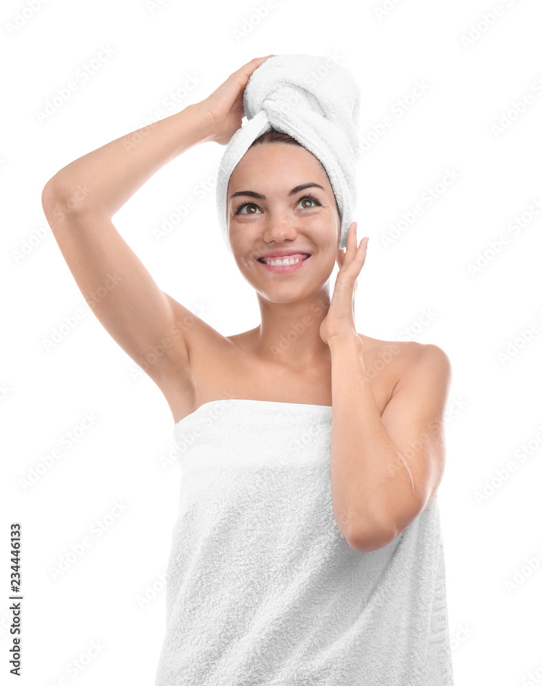 Beautiful young woman wrapped in towel on white background