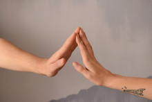 Man And Woman Touching Fingers On Grey Background