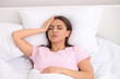 © Pixel-Shot - Woman suffering from headache in bedroom