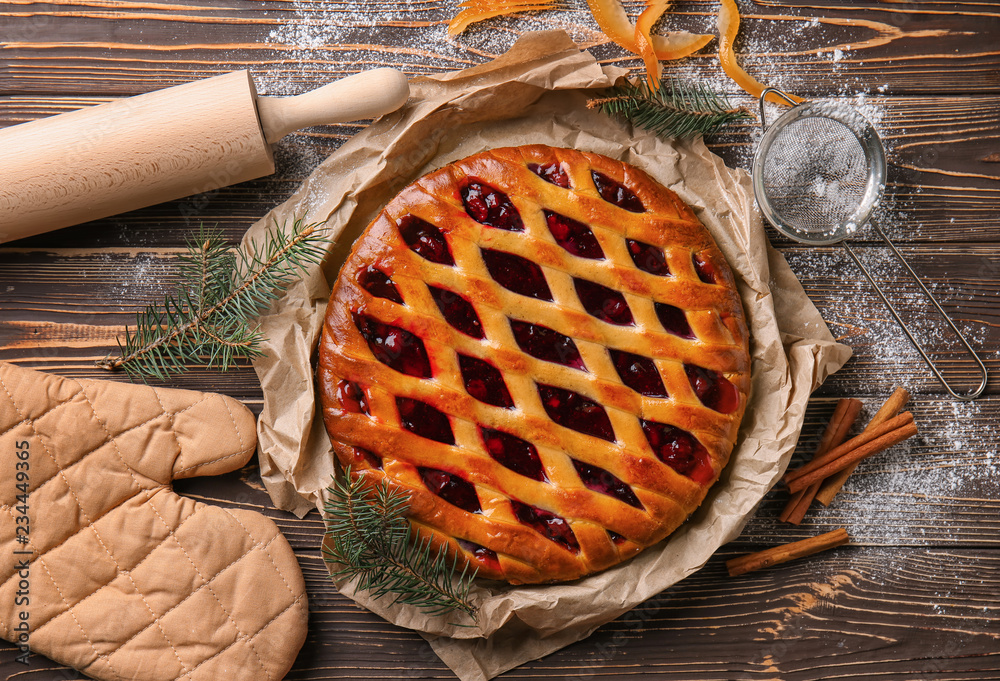 Tasty Christmas pie stuffed with cranberries on wooden table