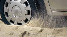 Spinning Wheel Of A Car Stuck In The Sand On A Sea Beach