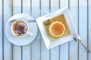 Wall Mural - coffee cup and Panna Cotta dessert on a wooden table